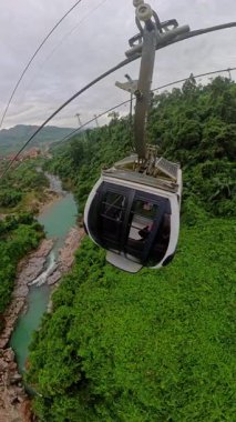 Dikey video. Kablo Araba Kayması Nehir ve Orman Tepeleri Geniş Açı Hava Perspektifi Açık Hava Gezisi Vurgusu Altında