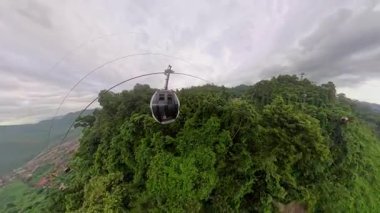 Yoğun Orman Tepesi 'ne yaklaşan Kablo Araba Güçlü Derinlik ve Dış Keşif Temalı Geniş Açı Hava Görünümü