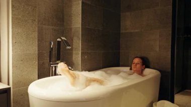 Geniş Açı Vurulan Kadın Bacak Yükseltme Suyu Parlak Küvette Rahatlamış Bir Atmosfer Oluşturuyor