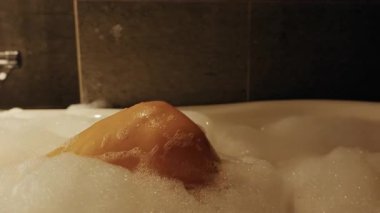 Derin Küvette Dinlenen Kadın Bacağında Köpük Tutarken Düşük Açı Vuruşu Rahatlatıcı Ruh Halini Vurguluyor