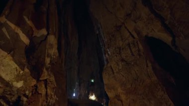 Altında Küçük Aydınlatma Yolu olan Büyük Dikey Mağara Duvarları Düşük Açı Görüş Alanında Dramatik Yeraltı Keşfi Sahnesi Yaratıyor