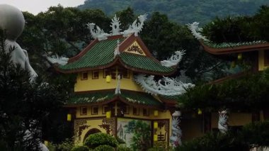 Dağ Eğimine Karşı Ağaçlar ve Kültürel Mimariye Karşı Çerçevelenmiş Yeşil Fayanslı Süslü Tapınak Çatı ve Beyaz Ejderha Tasarımları Orta Görünümü