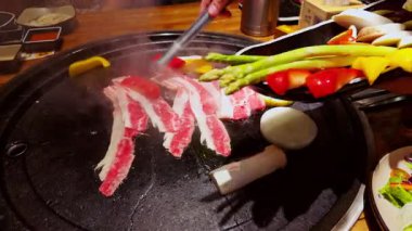 Buhar yükselirken ve içindekilerle birlikte elleri yana yatarken, Büyük Izgaraya Renkli Sebzeler Eklendi