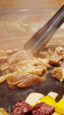 Dikey video. Salamura Et Dilimlerini Dilimleme Buharlı Sıcak Tabak Üzerinde Izgara İçin Düşük Açı Atışında Çevrilmiş Sebzelerle