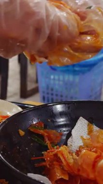 Dikey video. Eldivenli El Düşürme Karidesleri Kara Kâse 'ye, Deniz Ürünleri Hazırlama Konsepti için Düşük Açı Atışında Sulu Karides Tabağı' nın yanında