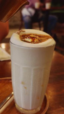 Dikey video. Wide Angle Slow Motion View of Taze Yumurta Kahvesi üzerine dökülüyor Tahta Masa üzerine, Cozy Cafe 'nin içinde Yumurta Kahvesi Konsepti