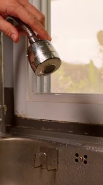 Dikey video. El Tutma Metal Spreyi Düşük Açı 'da Su Akıntısı' nı serbest bırakır Sıcak Günbatımı Işığı, Temiz Su Kullanımı Konsepti ile