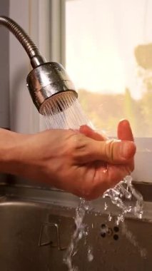 Dikey video. Düşük Açı, Temiz Rutin Konsepti 'nde, Sıcak Günbatımında Pencerenin Yakınındaki Açık Avuç Altında Sprey Akımı