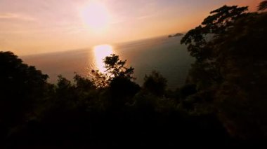 Hızlı İHA Uçuşu Sahil Ormanı 'ndan Açık Deniz' de Parlak Altın Gün batımına doğru kayıyor. Güçlü Hareket Bulanıklığı ve Okyanus Ufku 'nun Dinamik Açıklaması, Hız ve Özgürlük Konsepti ile.