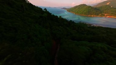 İHA İHA Uçuşu Tropikal Tepeler üzerinden Açık Su ve Eğri Sahil Kıyı Koyu 'na doğru Epik Hava Yolculuğu Konsepti' nin altında yükselen Kıvrımlı Kıyı Çizgisi ile Süpürüyor