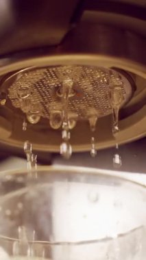 Dikey video. Espresso Makina Grubu başkanından akan Temiz Su Makro Görünümü Durulama Çemberi sırasında Damlacıklar Bardağa Sıçrıyor