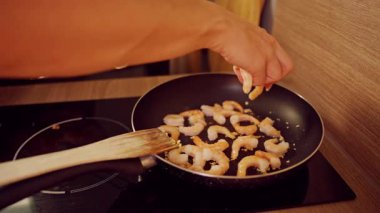 Yavaş Çekim: Karidesi elden ısıtma tavasına ekleyen Kadın Etkin Yemek Pişirme Süreci ve Deniz Ürünleri Hazırlama Süreci