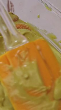 Dikey video. Yeşil Krem, Savoiardi Bisküvileri 'nin üzerine Cam Tabakta Spatula ile pürüzsüzce yayılıyor, Son Tiramisu Katman Hazırlanmasının Ayrıntılı Görünümü