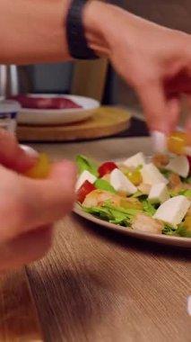 Dikey video. Kadın Elleri Mutfak tezgahında Peynir ve Domateslerle Salata Dekorasyonu, Taze Ev Yemeği Hazırlama