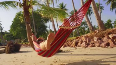 Hamaktaki Kadın Ayakları 'nın Düşük Açılı Görünümü Sandy Plajı' ndaki Palmiye Ağaçları Altında Tropikal Rahatlamanın Sinema Perspektifi