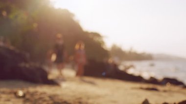 Gün batımında kumsalda yürüyen bulanık insanlar Yumuşak Odaklanma ve Sıcaklık, Hayalperest Vurgulama Boş Anılar, Seyahat Anıları, Yaz Yaşam Tarzı