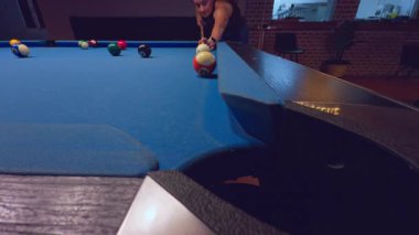 Düşük açılı bilardo masası manzaralı, içinde kadın olan cep odası. Demiryolu boyunca ateş edilmiş. Atmosferik Bilardo Kulübü.