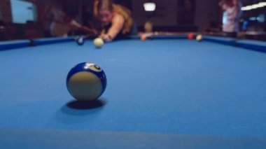 Kadınlar bilardo kulübünün arka planına işaret koyarken Mavi ve Beyaz Bilardo Topunun Kapanışı