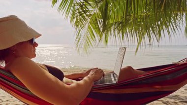 Sıcak Tropikal Gün 'de Hamakta Yüzü Parlayan Deniz Altında Çalışan Kadın Dizüstü Bilgisayarda Çalışıyor