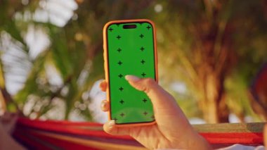 Hamakta Sallanan Kadın Akıllı Telefon Tropik Palm Garden 'da Yeşil Ekran ile Kaydırırken, Sosyal Medya Taraması ve Rahat Mobil Yaşam Taraması Gösteren İlk Kişi Görünümü