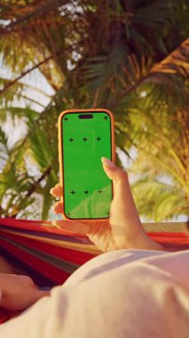 Dikey video. Tropikal Palm Garden 'da Yeşil Ekran ile Hamak Yapan Kadın Hareketi, İlk Kişi Görünümü Dokunuş ve Rahat Mobil Kullanım Etkileşimi