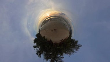 Kıvrımlı Palmiyeler ve Yumuşak Altın Günbatımı ile çevrili Küçük Gezegen Manzarası 'nda Bir Kum Tropikal Sahilde Bir İki Oturuş Sakin Kıyı Sahnesinde Romantik Bir Atmosfer Oluşturuyor