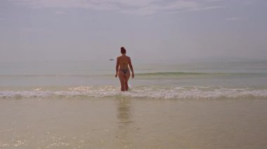 Yumuşak Güneş Işığı Yumuşak Dalgalarda Yansıyarak Huzurlu Bir Tropik Plaj Atmosferi Oluştururken Bir Kadın Sığ Deniz Suyunda Ufka Yüzleşir