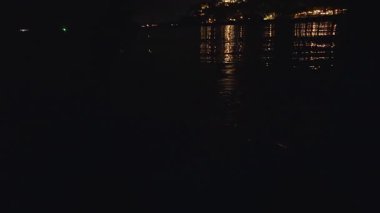 Mavi Biyolüminesans Plankton 'lu Gece Denizi Sahnesi Kürek tahtasından Uyanış ve Karanlık Su Yansıyan Şehir Işıkları Atmosferik Ortam Oluşturuyor