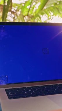 Dikey video. Mavi Krom Ekranlı Laptop Palm Trees 'in Altında Yakından Bakılan Hamak Dijital Göçebe Yaşam Tarzı ve Açık Hava İş Dengesi Gösteriyor