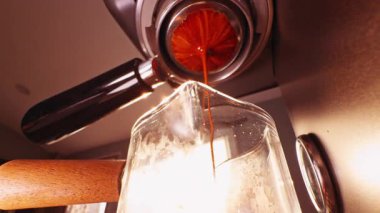 Barista 'nın sıcak güneş ışığı altında taze demlenmiş Espresso bardağını tutarken düşük açılı görüntüsü Sabah Kahvesi Ritüeli oluşturur