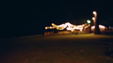 Konforlu plaj çimenliği, asılı ipe bağlı ışıklar ve boş şezlonglar geceleri dinlenme ve akşam keyfi yaratır.