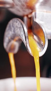 Dikey video. Metal Portafilter 'dan Fincan' a fışkıran Altın Espresso 'nun Yakından Bakış Akışı Taze Krema oluşumunu ve Profesyonel Kahve Hazırlarken Zengin Doku