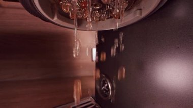 Close Up View of Hot Water Flushing From Espresso Machine Group Head During Cleaning Process Showing Maintenance Routine and Hygiene of Professional Coffee Equipment