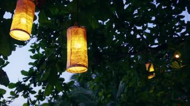 Alacakaranlıkta Parlayan Sıcak Kağıt Fenerler, Sıcak Akşam Işığı ve Neşeli Bahçe Atmosferinde Tropikal Yapraklar Arasında Parlayan