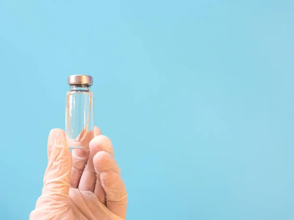 Бутылка с вакциной в руках в медицинских перчатках — стоковое фото