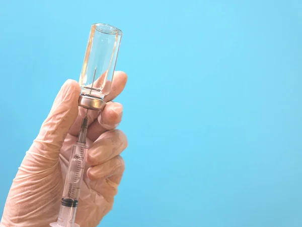 Injectiespuit Met Vaccin Hand Medische Handschoenen Blauwe Achtergrond — Stockfoto
