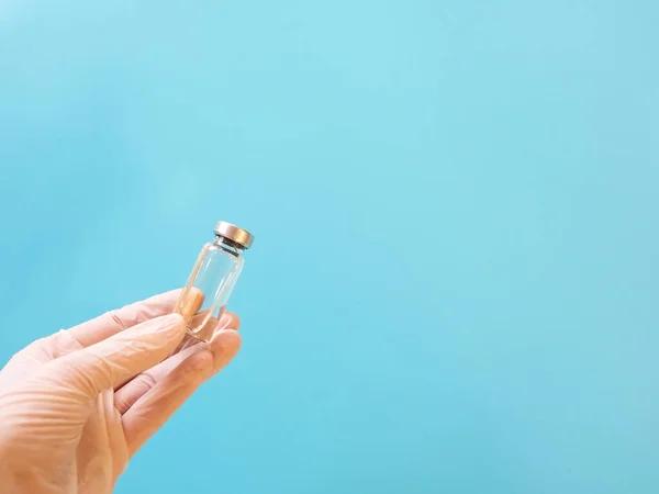 Fles Met Vaccin Hand Medische Handschoenen Blauwe Achtergrond — Stockfoto