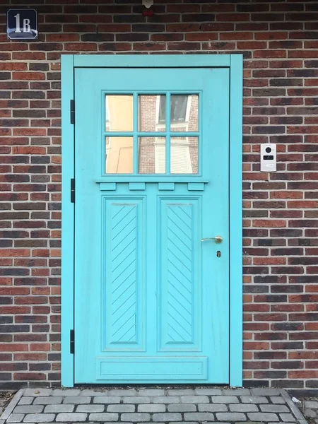 Hermosa puerta azul en una pared de ladrillo — Foto de Stock