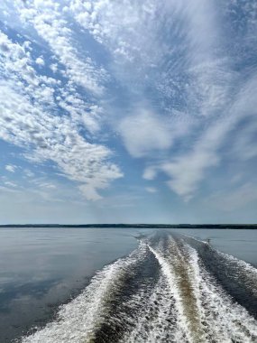 Güzel nehir manzarası, bir tekne motoru ve gökyüzünden gelen simetrik dalgalar..