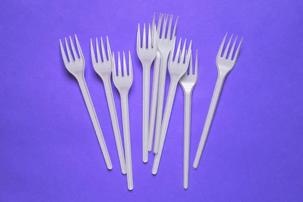 Bílé Plastové Vidličky Fialovém Pozadí Jednorázové Nádobí Piknik Oběd Nebo — Stock fotografie