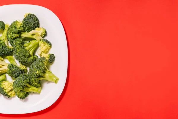 Broccoli Lastra Bianca Fondo Rosso Con Spazio Copiare Verdura Matura — Foto Stock