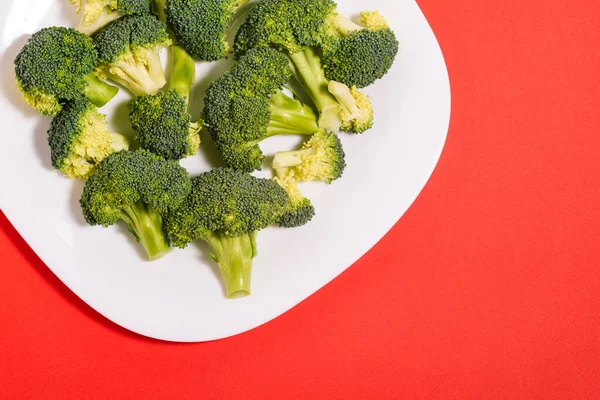 Broccoli Nära Håll Färsk Broccoli Tallrik Röd Bakgrund Hälsosam Och — Stockfoto