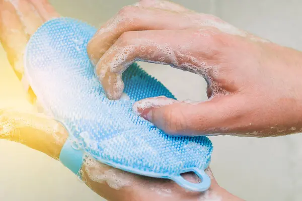 Washing hands with soap. A woman cleans her hands from viruses with a blue brush. Coronavirus prevention, hygiene. Protection from infection.