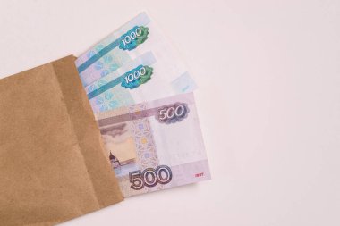 Rus parası yığını ve beyaz arka planda bir zarf. Şirket vergilerinden kaçınmak.