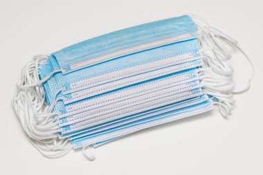 Tıbbi maskeler beyaza takıldı. Tek kullanımlık cerrahi maske, koronavirüs, toz, kir, grip ve bakterilere karşı korur. Solunum, ağız ve burun koruması. Tıbbi ekipmanlar, sağlık hizmetleri.