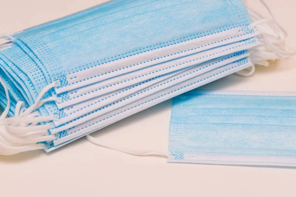 Kulaklıklı maskelerin çoğu beyaz arka planda 3 katmanlı koruyucu maskelerdir. Tıbbi maskelere yakın çekim. Toz, mikrop ve koronavirüsten korumak için solunum cihazı.