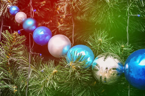 Ağaçta kocaman Noel topları var. Oyuncaklı ladin yeşili dallar. Parlak çelenkler yakın plan. Noel arkaplanı. Yeni yıl kavramı.