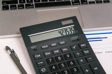 Hesap makinesi, kalem ve defter, kapatın. Finansal açıklamalar. Belgeler ofisteki masaüstünde. Şirket bildiriyor. İş konsepti