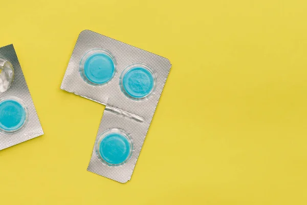 Kulaté Pilulky Žlutém Pozadí Kopírovacím Prostorem Léky Stříbrném Obalu Tablety — Stock fotografie