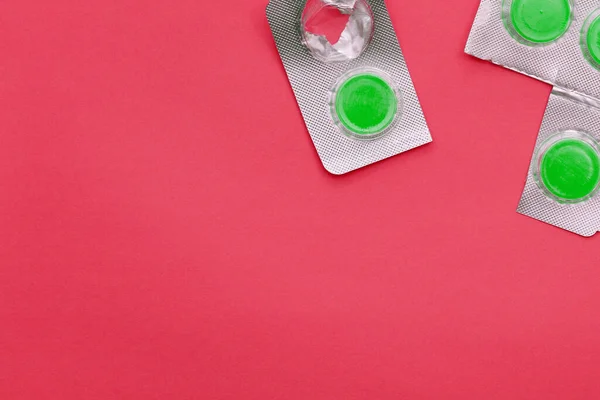 Zelené Pilulky Červeném Pozadí Stříbrném Balení Léky Proti Bolestem Hlavy — Stock fotografie